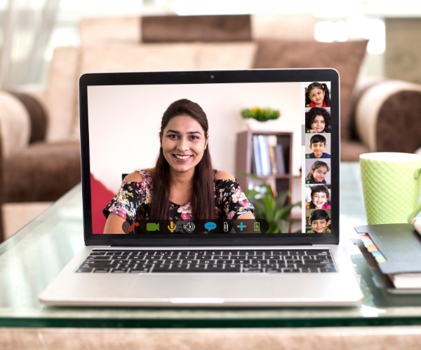 Laptopscherm met een docent en haar leerlingen in een online les.