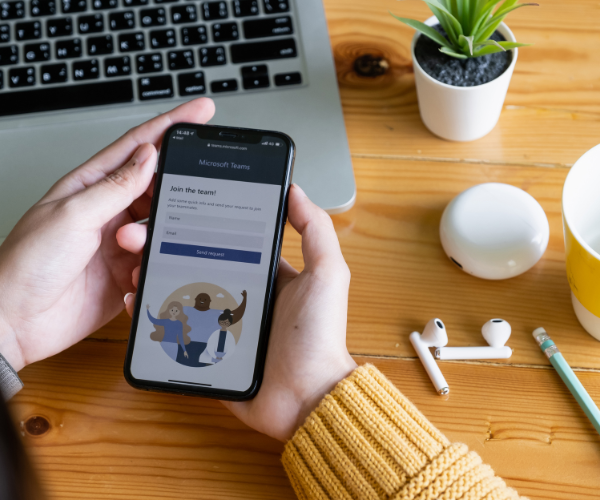 Iemand met een smartphone met Microsoft 365 Teams.
